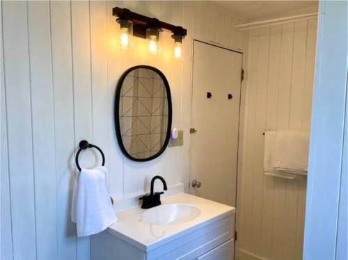 uma casa de banho com um lavatório e um espelho em The Barn at Evermore: riverfront retreat w/hot tub em Luray