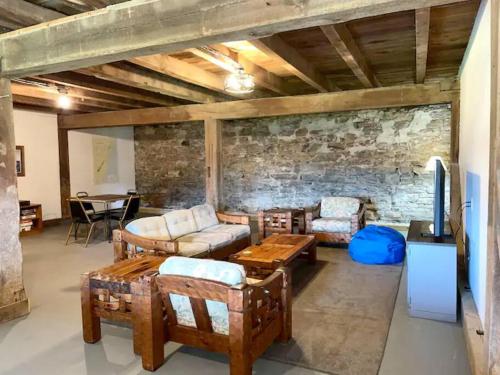 uma sala de estar cheia de mobiliário e uma parede de tijolos em The Barn at Evermore: riverfront retreat w/hot tub em Luray