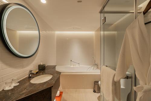 a bathroom with a sink and a mirror at DoubleTree by Hilton Bangkok Ploenchit in Bangkok