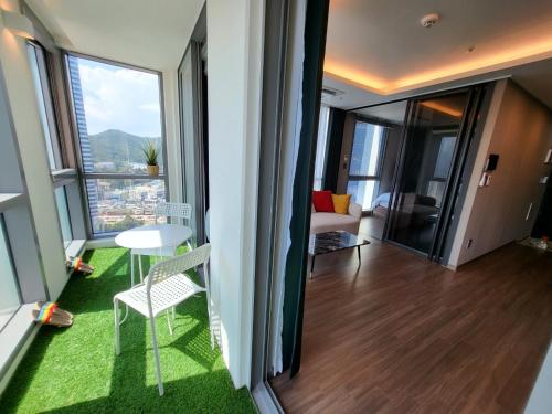 a room with a table and chairs and a room with a view at ELBON the stay Haeundae beach ocean view in Busan