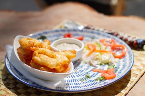 a blue and white plate with a bowl of food at Kupaga Villas Boutique Hotel - Adults Only in Jambiani