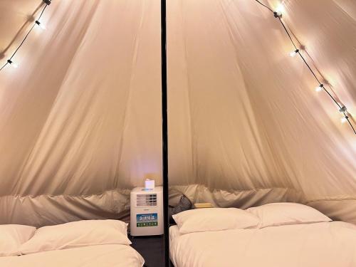 a tent with two beds and a machine in it at Touching Camping in Hou-lung-tzu