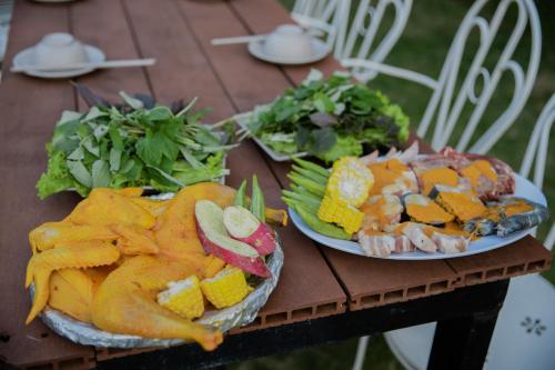 two plates of food sitting on a wooden table at SEN VILLA Boutique in Bao Loc