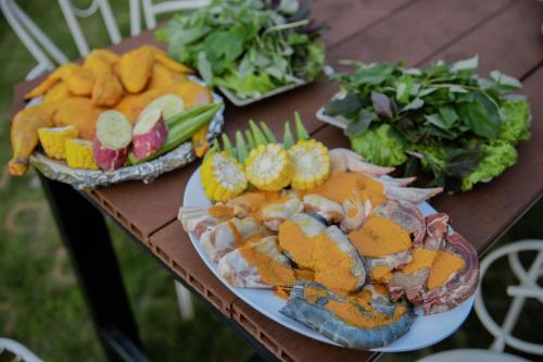 a wooden table with plates of food on it at SEN VILLA Boutique in Bao Loc