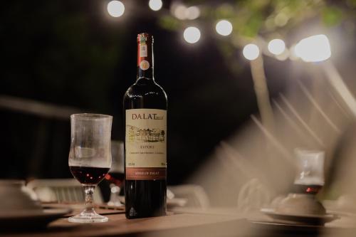 a bottle of wine sitting on a table with a glass at SEN VILLA Boutique in Bao Loc