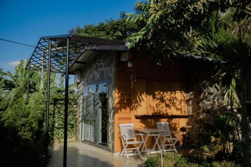 two chairs and a table outside of a house at SEN VILLA Boutique in Bao Loc