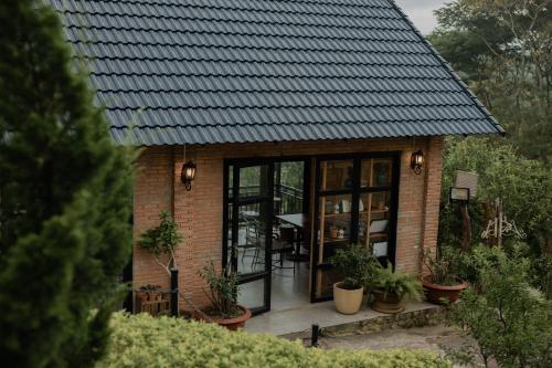 a small brick house with a black roof at SEN VILLA Boutique in Bao Loc
