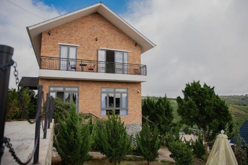 a brick house with a balcony on top of it at SEN VILLA Boutique in Bao Loc