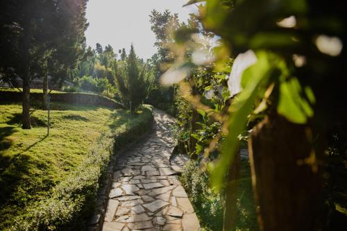 a stone path in a garden with a fence at SEN VILLA Boutique in Bao Loc