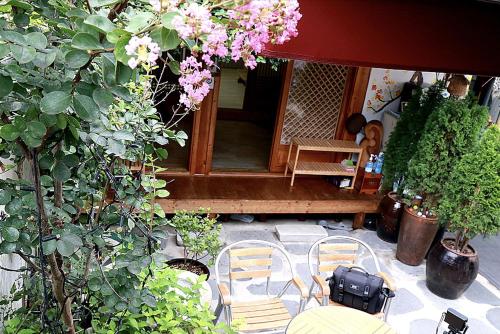 a patio with a table and chairs and flowers at Hanok Story Guesthouse in Jeonju