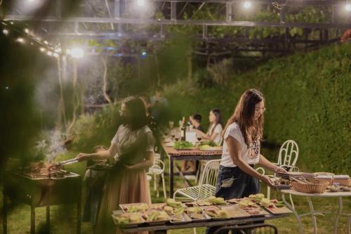 two women preparing food at an outdoor event at SEN VILLA Boutique in Bao Loc