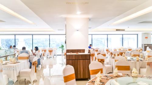 a dining room with white tables and white chairs at YEN BIEN LUXURY HOTEL in Ha Giang