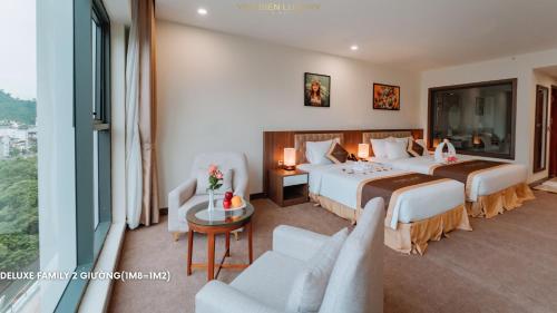a hotel room with two beds and a table and chairs at YEN BIEN LUXURY HOTEL in Ha Giang