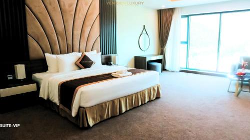 a bedroom with a large bed with a large window at YEN BIEN LUXURY HOTEL in Ha Giang