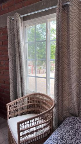 a wicker chair sitting in front of a window at Rancho Matalote en Valle de Guadalupe in Valle de Guadalupe