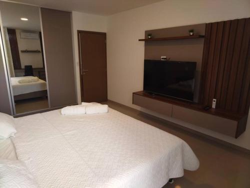 1 dormitorio con 1 cama grande y TV de pantalla plana en Moderno departamento Equipetrol Santa Cruz, en Santa Cruz de la Sierra