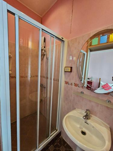 a bathroom with a shower and a sink and a mirror at Samsen Sam Place in Bangkok