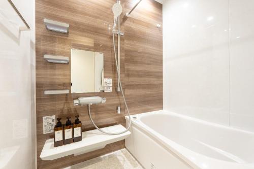a bathroom with a tub and a toilet and a sink at The Lodge Yamanakako by n'estate Tsutsuji in Yamanakako