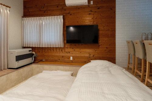 a bed in a room with a tv and a bed sidx sidx sidx at n'estate Yamanakako Tsutsuji in Yamanakako