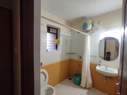 a bathroom with a sink and a toilet and a mirror at Beach Apartment 2,COLVA , GOA, INDIA in Colva