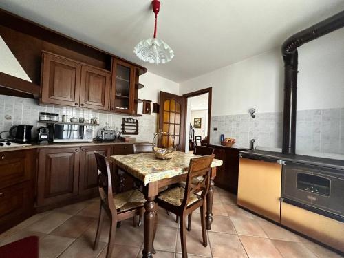 a kitchen with a table with chairs and a stove at Baita pressi Gran Paradiso in Sparone