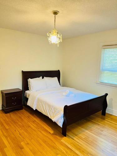a bedroom with a large bed and a chandelier at River Haven in Mississauga