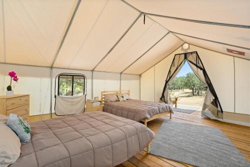 1 dormitorio con 2 camas en una tienda de campaña en Twin Falls Luxury Glamping - Cozy Retreat, en Boerne