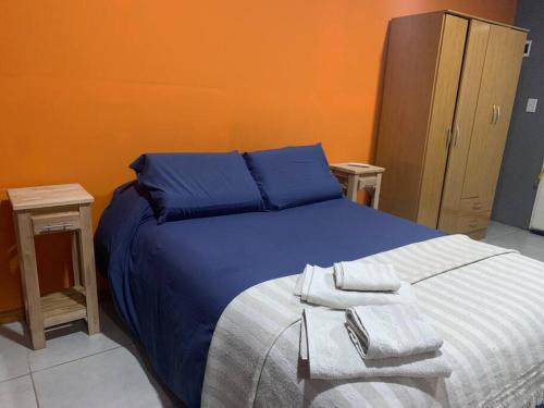 1 dormitorio con 1 cama azul y 2 mesitas de noche en Departamento Dulce Manía 1 en Carhué