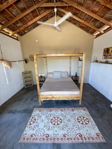 a bedroom with a bed with a rug and a ceiling at Gypsea Cabana in Arugam Bay