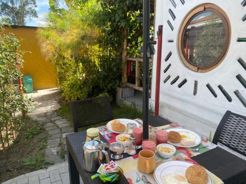 a table with plates of breakfast food on it at Hostería Colibri Aeropuerto in Tababela