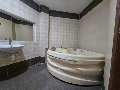a bathroom with a tub and a sink at Veer Hotel in Kuantan