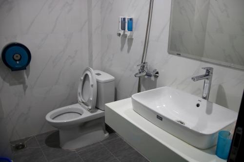 une salle de bain blanche avec toilettes et lavabo dans l'établissement Minh Quân Hotel HN - by BAY LUXURY, à Thượng Thôn