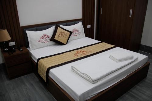 une chambre avec un lit avec des draps blancs et des oreillers dans l'établissement Minh Quân Hotel HN - by BAY LUXURY, à Thượng Thôn