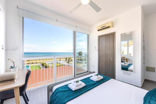 een slaapkamer met een bed en uitzicht op de oceaan bij Ayia Thekla Seafront Villa Dagi in Ayia Napa