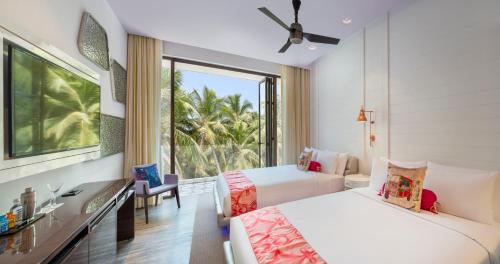a bedroom with two beds and a large window at W Goa in Vagator