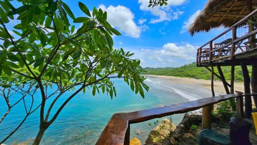 a view of the beach from a resort balcony at Monkey House Hostel in Tola