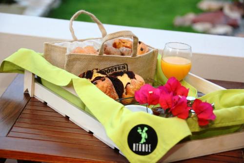 a basket of bread and a glass of orange juice at Ventoura Studios & Apartments in Galissas