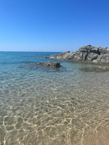 a sandy beach with rocks in the water at Casa Stewart - Ponente in Geremèas