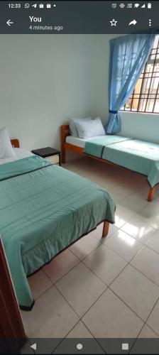 - 2 lits dans une chambre avec fenêtre dans l'établissement Raudhah family homestay at KLIA 3rooms & 2bath room, à Sepang