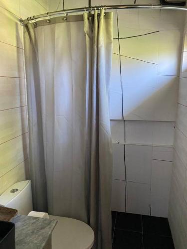 a bathroom with a shower curtain and a toilet at Brisa de Cristal at Canyon Cove Nasugbu Batangas in Nasugbu