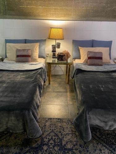 1 dormitorio con 2 camas y mesa con lámpara en Sapphire, en Riad