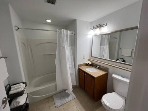 ein Bad mit einer Dusche, einem WC und einem Waschbecken in der Unterkunft Huge Pool, Sunrise Lakeview 12th floor near Disney in Orlando