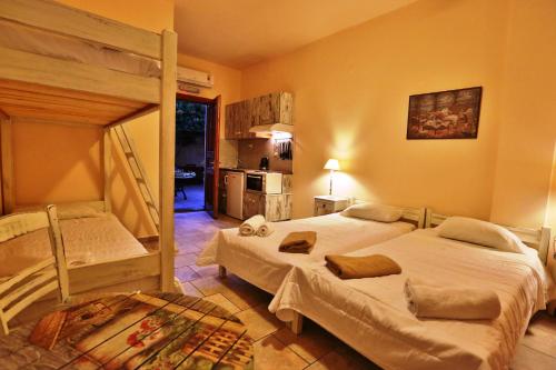 a bedroom with two bunk beds and a kitchen at Ventoura Studios & Apartments in Galissas