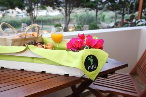 a table with a basket of food and a glass of orange juice at Ventoura Studios & Apartments in Galissas