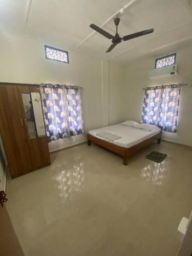 a room with a bed and two windows at Winter Sky - a 2bhk beautiful apartment in Tinsukia