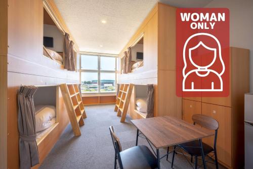 a room with a table and a room with bunk beds at KIBOTCHA/キボッチャ in Higashimatsushima