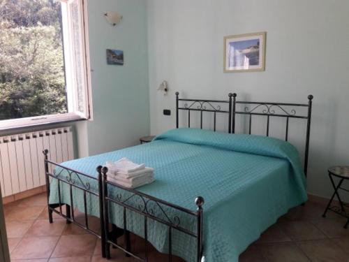 una camera da letto con un letto con un piumone verde e una finestra di MammaLisa Casa Vacanze a Colonnella