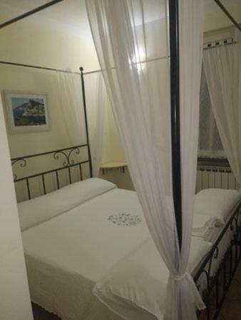 una camera con 2 letti e tende bianche di MammaLisa Casa Vacanze a Colonnella