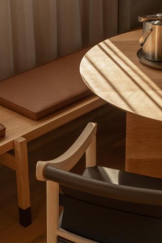 a wooden table with a chair next to a wooden table at Hotel Marvell Byron Bay in Byron Bay