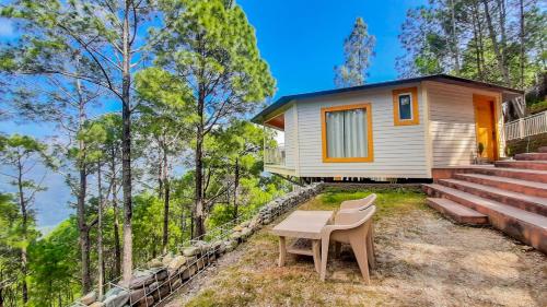 a tiny house in the woods with a table and chairs at The Woods Retreat in Lansdowne